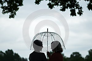Two women walking park in rain and talk. Friendship and people communication. Rainy