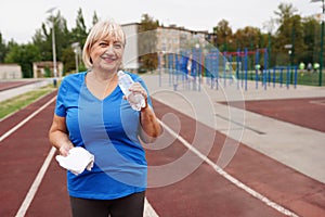 Two Women with water bottle smiling. Senior ladies outdoors. New program of aerobic trainings photo