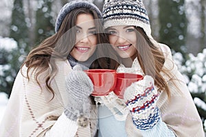 Two women in winter clothes with hot chocolate