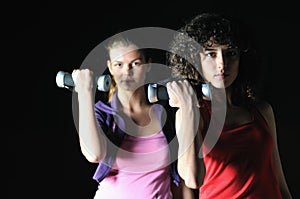 Two women work out in fitness club