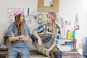 two women workers in workshop looking at each other