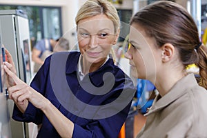 two women working with machine units at modern plant