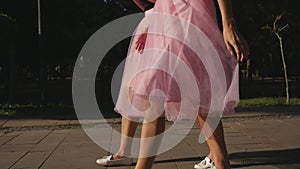 Two womens legs in tulle skirts and sneakers walking outdoors