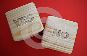 Two wood blocks with words: yes - no on red background