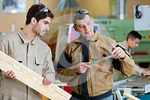 two wood designer working with laptop in workshop