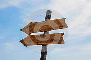 Two wooden arrow pointers mockup on blue sky background. Wooden Arrow Sign outdoor