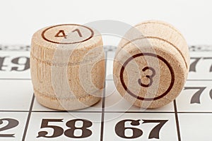Two wooden barrel numbers and card for a lotto game on a white background.
