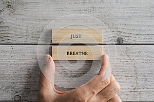 Two wooden blocks with a Just breathe sign on them