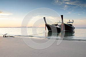 Two wooden boats on a beach at sunrise time