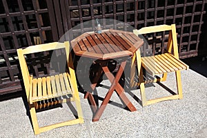 Two wooden chairs with a wooden table mismatched
