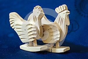 Two wooden chickens on blue