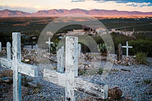 Two wooden cross grave markers overlooking sunset over hills in Boothill graveyard in Tombstone