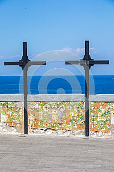 Two wooden crosses with a low wall decorated with religious icons overlooking the sea. Location: Forio, Soccorso Church photo