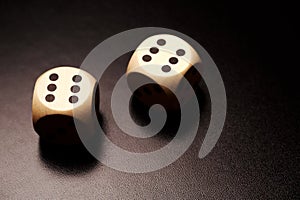 Two wooden dices on a black background