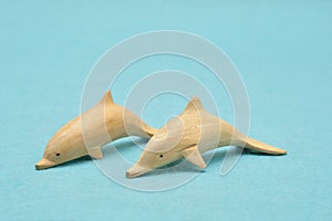 Two wooden dolphin figurines