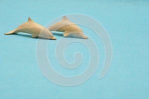 Two wooden dolphin figurines