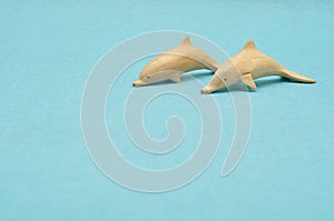 Two wooden dolphin figurines