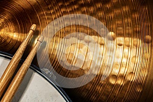 Two wooden drumsticks on a snare drum and golden cymbal - Percussion instrument