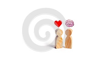 Two wooden figures with the image of the brain and heart. The balance between love and mind. Family versus career or work. Family