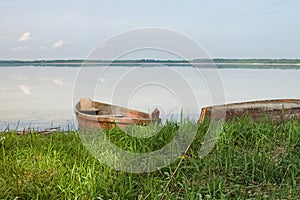 Two wooden fishing boats on bank of the lake. Spring landscape photo. Lake Svityaz. Volyn region. Ukraine