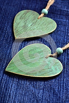 Two wooden hearts on blue denim background