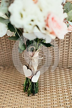 Two wooden hearts with bow on wedding bouquet