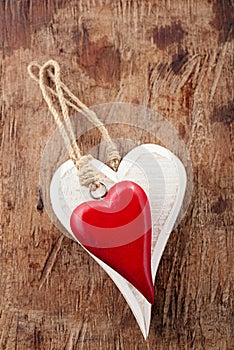 Two wooden hearts, red and white on old wood