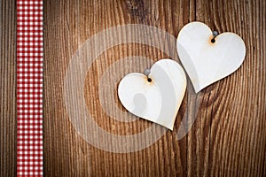 Two wooden hearts on sun burned wood