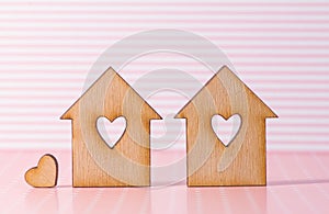 Two wooden houses with hole in the form of heart with little hea