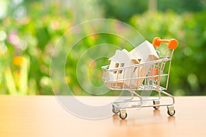 Two wooden houses in a trading cart on nature background. The concept of buying and selling real estate, renting. Attractive