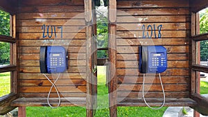 Two wooden phone booths with pay phones.The concept for the new year to 2018.