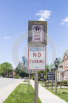 Two wooden red and white signs that says No Parking and No Bike Parking