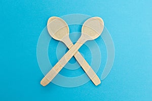 Two wooden spoons with instant dry yeast isolated on a blue background. Yeast is the main ingredient of fresh dough for pastry,