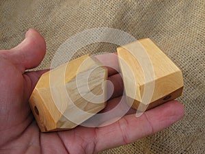 Two wooden stones for tumi ishi toy on a man`s palm