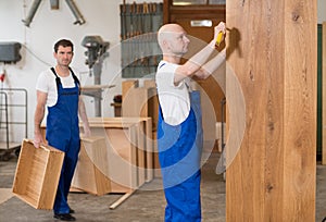 Two worker in a carpenter`s workshop