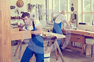 Two worker in a carpenter`s workshop