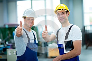 Two worker in factory with thumb up