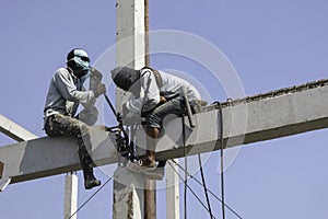 Two worker man welding steel concrete pile high house structure in construction site. labor man working high pile no safety . long