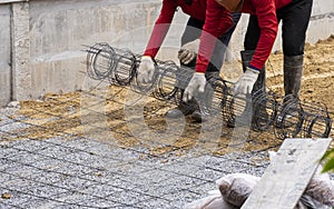 Two worker team work install wire mesh on sand floor for reinforce concrete before fill liquid cement on road