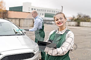 Two workers on car service posing near car