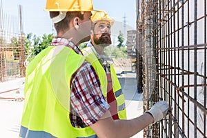 Two workers checking the durability of the steel structure