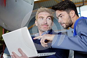 Two workers checking satellite issue dish in laptop