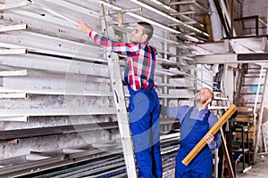 Two workers choosing PVC window profile