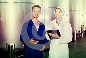 Two workers in coats on winery manufactory