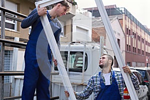 Two workers delivering PVC profiles