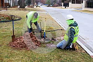Workers fixing leak on water meter and digging out very wet mud on cold day in Tulsa Oklahoma USA 2 22 2018