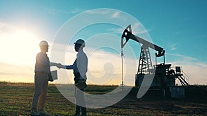 Two workers handshake agreement at oil field