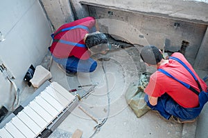 Two workers have made a niche for radiators in