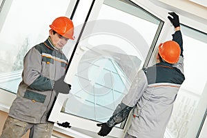 Two workers installing window