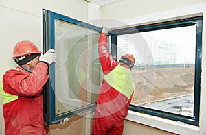 Two workers installing window